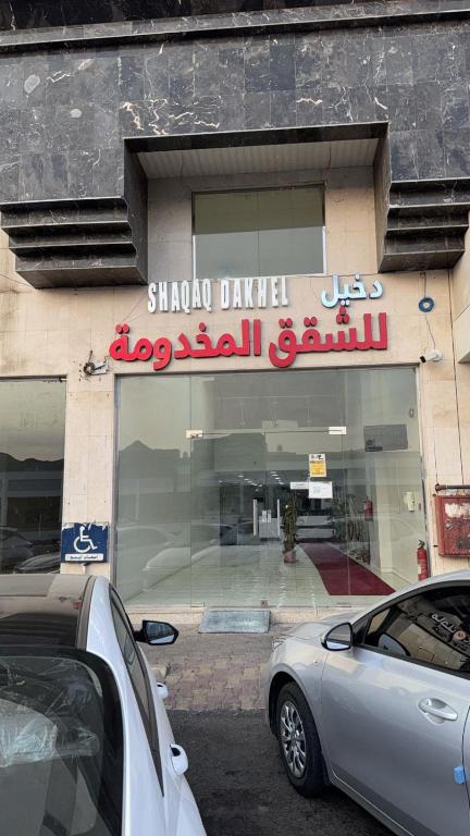 a store front with a sign on a building at شقق دخيل بن نقا بن شنيشيل الرحيلي للشقق المخدومة in Medina