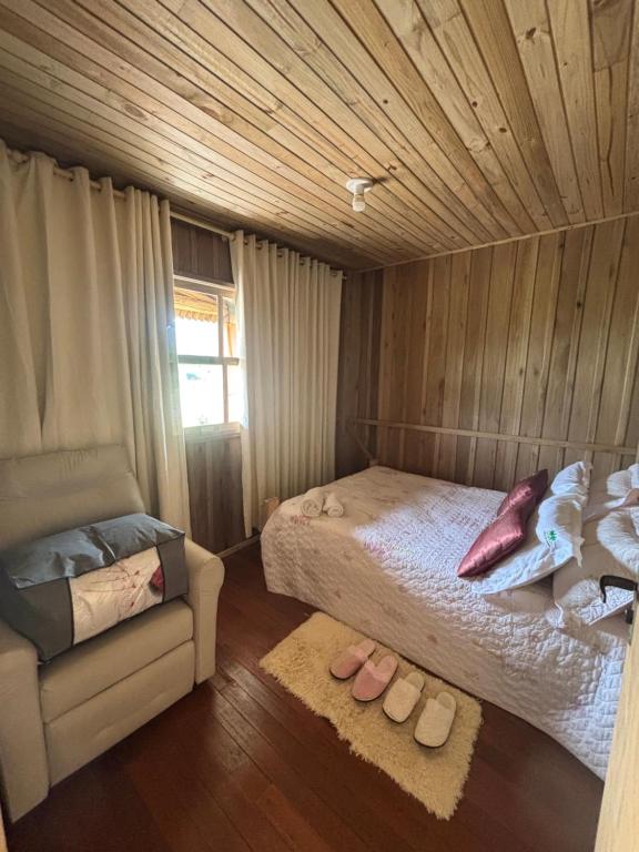 Un dormitorio con una cama, un sofá y una silla. en Pousada dos Sonhos - Casa Goiabeira, en Timbe do Sul