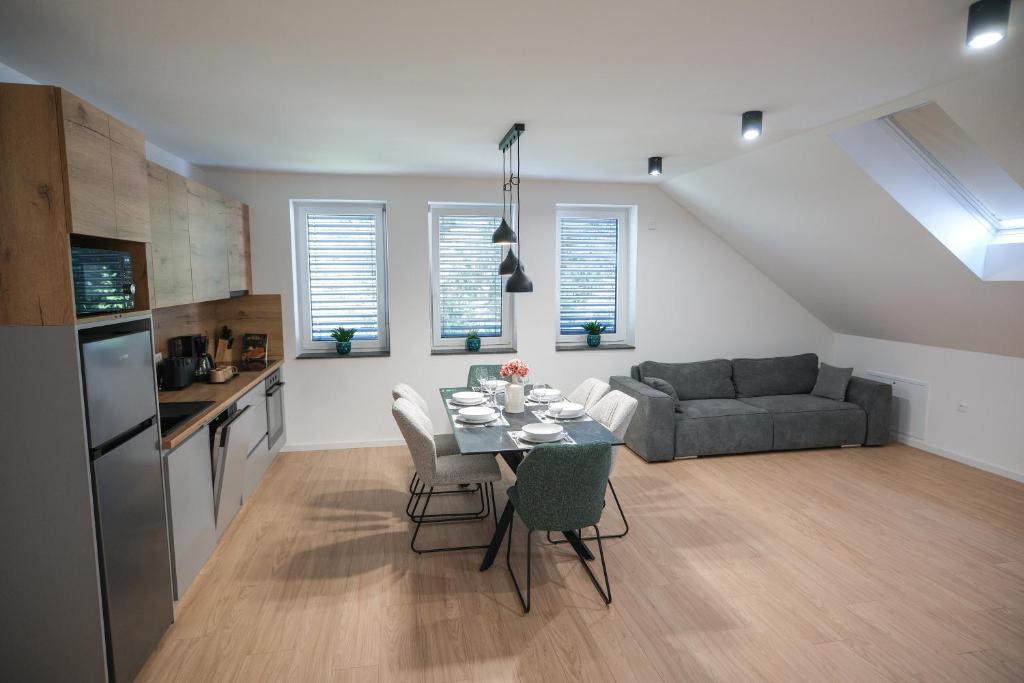 a kitchen and living room with a table and a couch at Apartma Ana in Krško
