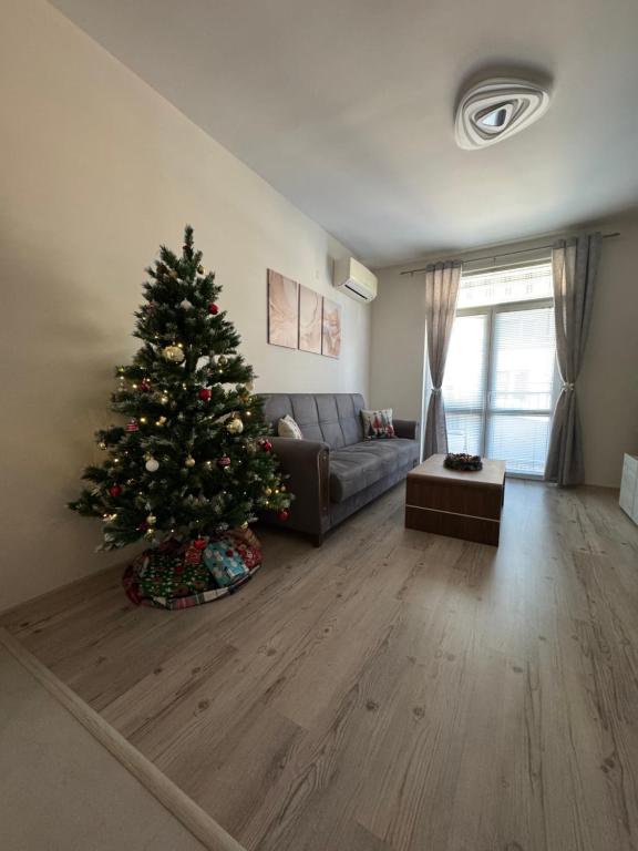 a christmas tree in a living room with a couch at Апартамент за гости Кари in Stara Zagora