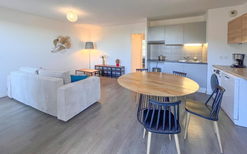 a living room and kitchen with a table and a couch at Cenon plein ciel in Cenon