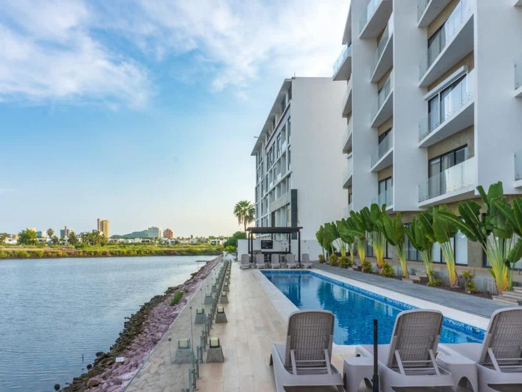 einen Pool mit Stühlen neben einem Gebäude in der Unterkunft Marina view pool and restaurants nearby in San Rafael