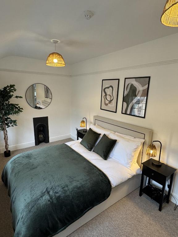 a bedroom with a large bed and a fireplace at Kingsmead Square Apartments in Bath