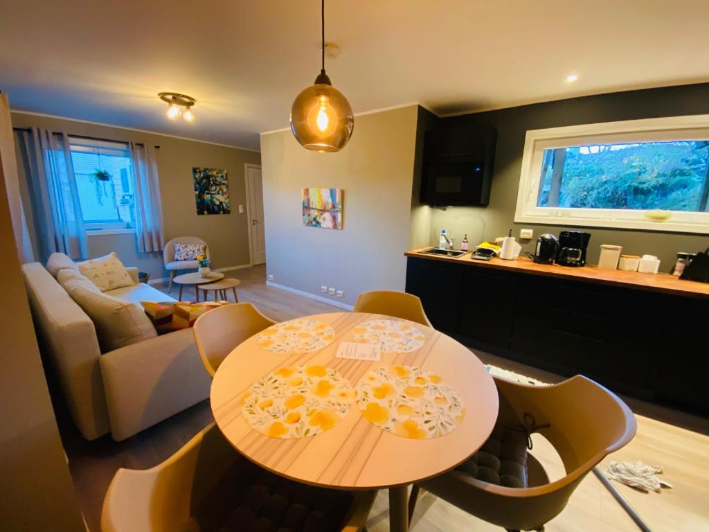 a kitchen and living room with a table and chairs at Leilighet i sentrum in Sokndal