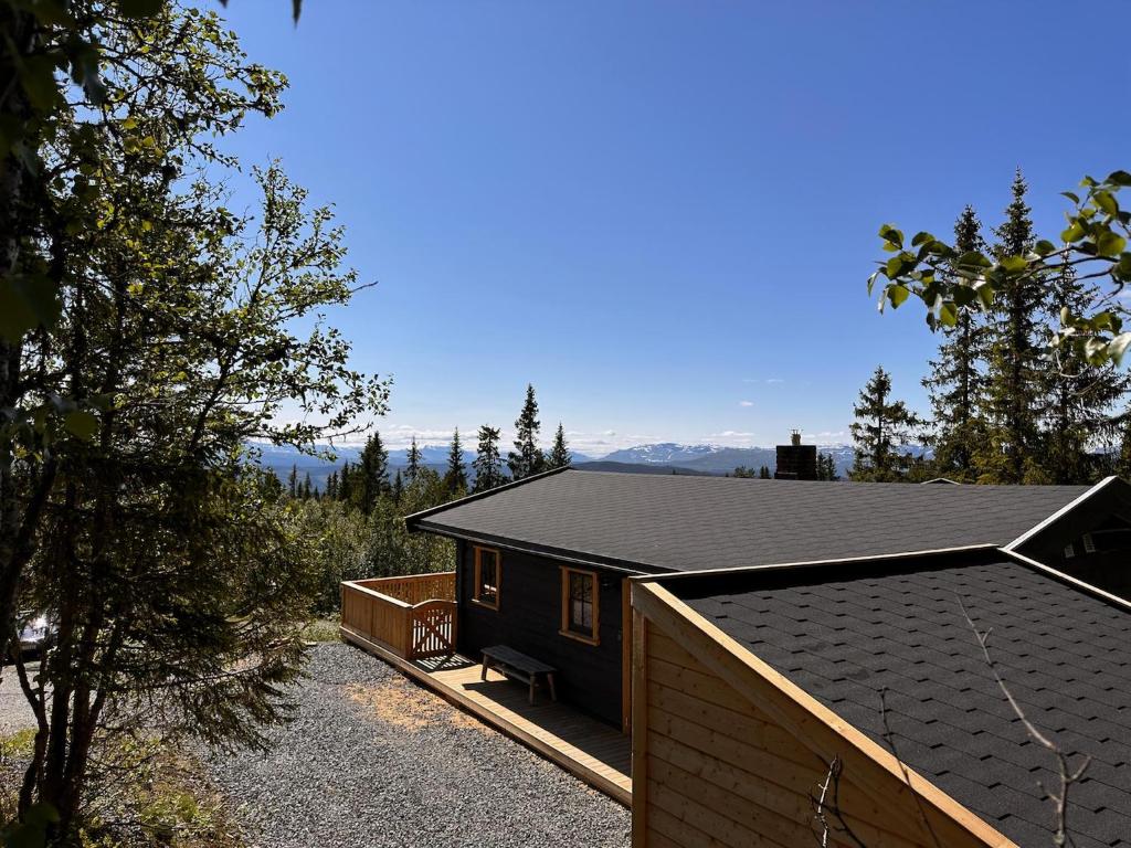 ein Haus mit einem schwarzen Dach darüber in der Unterkunft Modern Cozy Cabin Near Langsua National Park in Heggenes