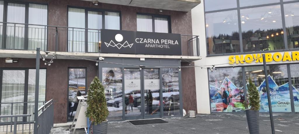 a building with a sign on the side of it at Czarna Perła Apartamenty Czarna Góra 203 in Sienna