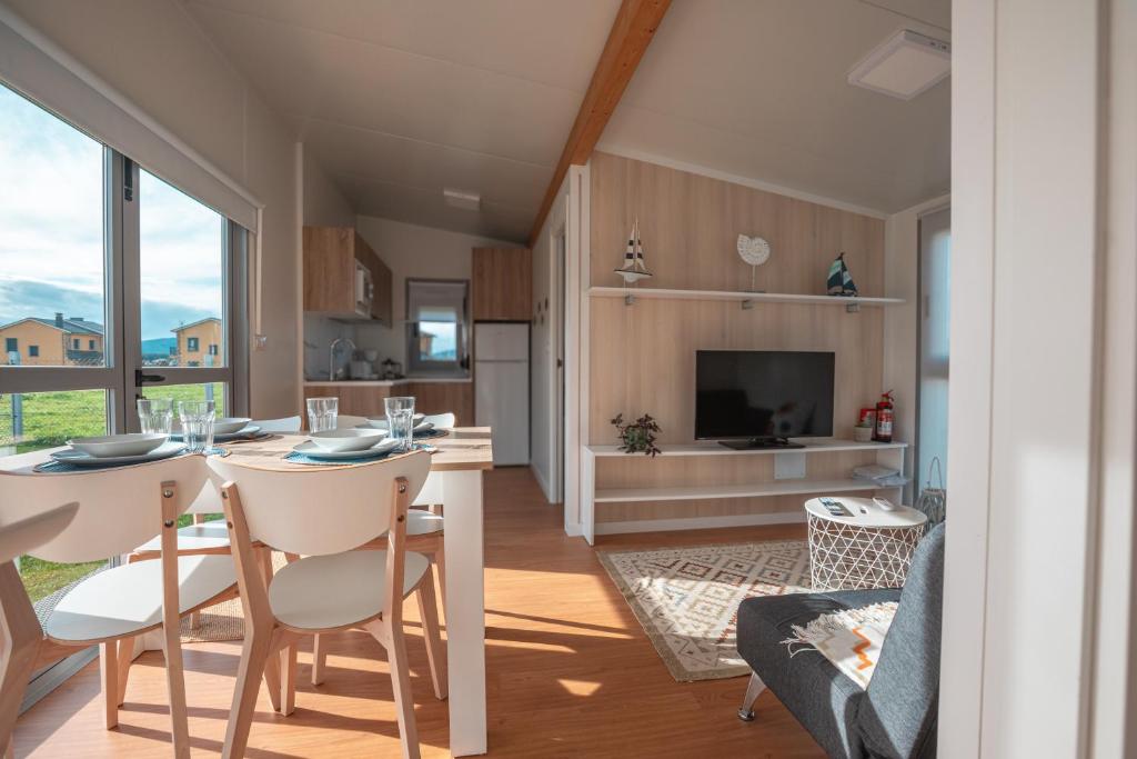 a kitchen and living room with a table and chairs at Balea House in Barreiros