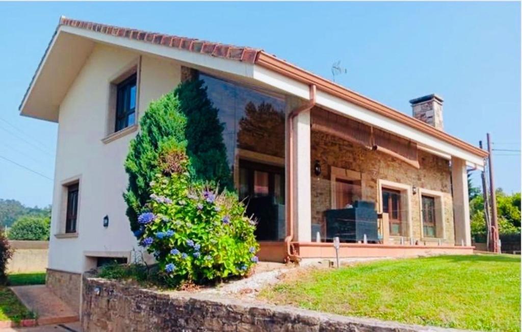 une maison avec un arbre sur son côté dans l'établissement Villa Mauricio Garden, 