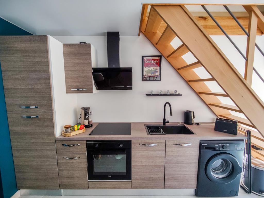 a kitchen with a stove and a washer and dryer at Ateliers des rêves - climatisé, Dijon centre in Dijon
