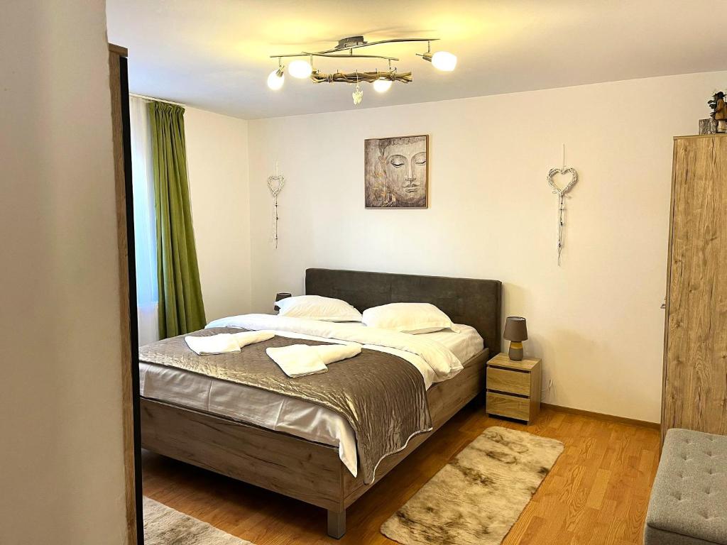 a bedroom with a bed with two towels on it at Rustic Breeze Azuga - BBQ, Fireplace and Parking in Azuga