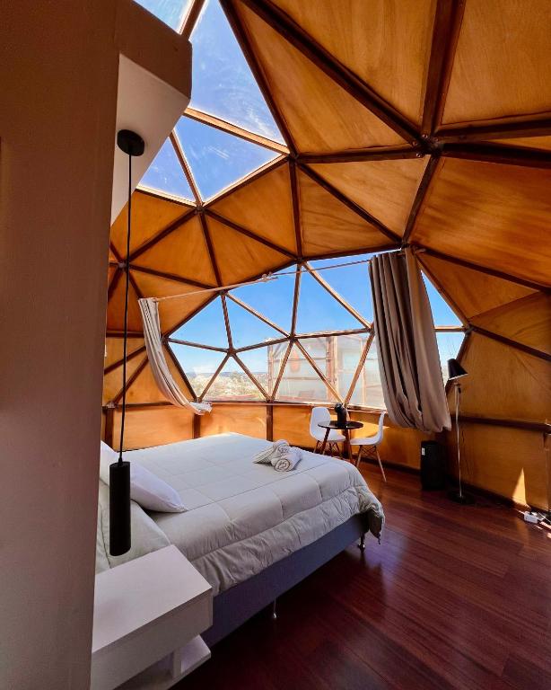 Schlafzimmer mit einer großen Glasdecke und einem Bett in der Unterkunft Secreto Sierras Domos Boutique con Jacuzzi y Desayuno in Aiguá