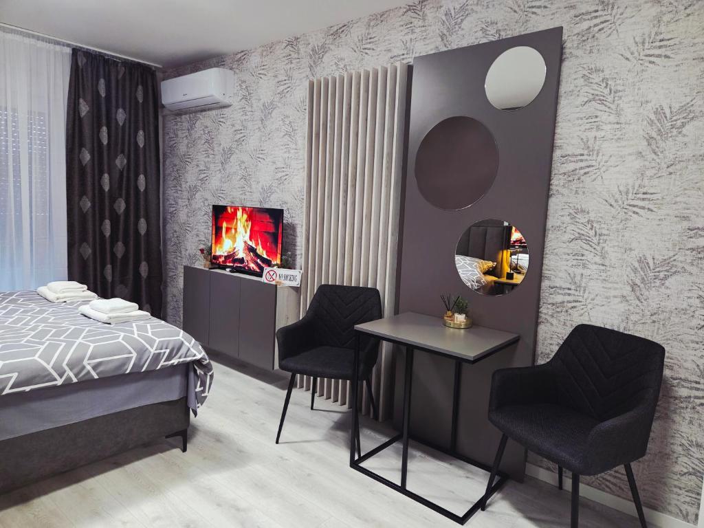 a bedroom with a bed and two chairs and a table at Apartman Elite Stay Doboj in Doboj