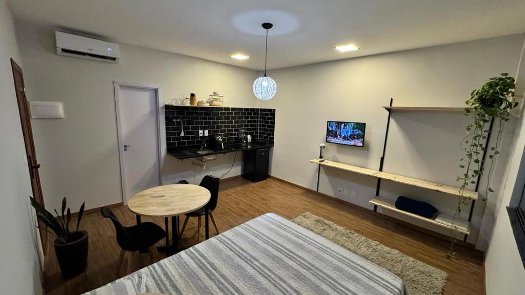 a living room with a table and chairs and a kitchen at Loft Salvador in Salvador