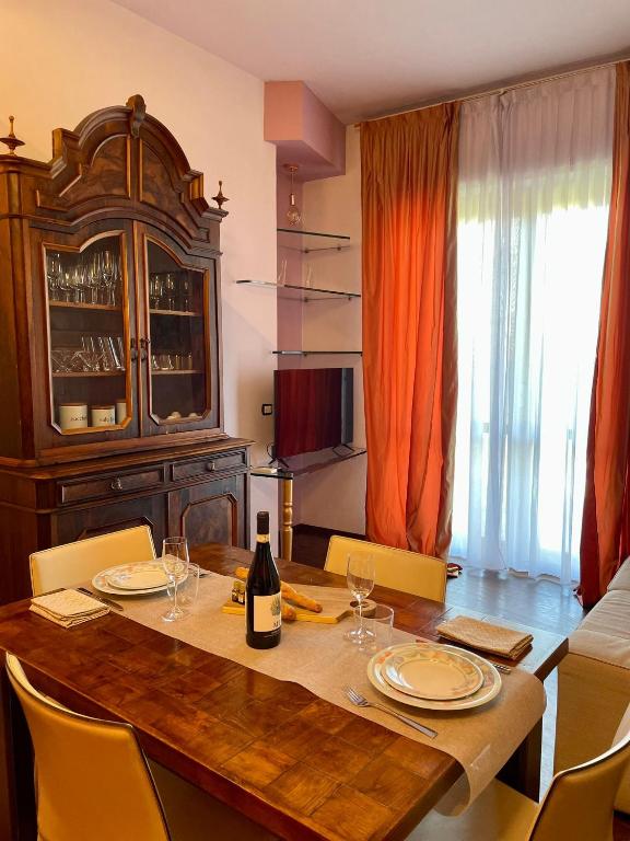 a dining room table with a bottle of wine on it at Il nido di Sonia - Wi-Fi, aria condizionata e free park in Asti