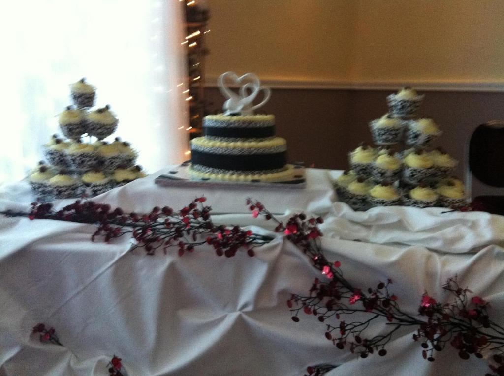 a table with a wedding cake and cupcakes on it at Ashbourne House Hotel in Ashbourne