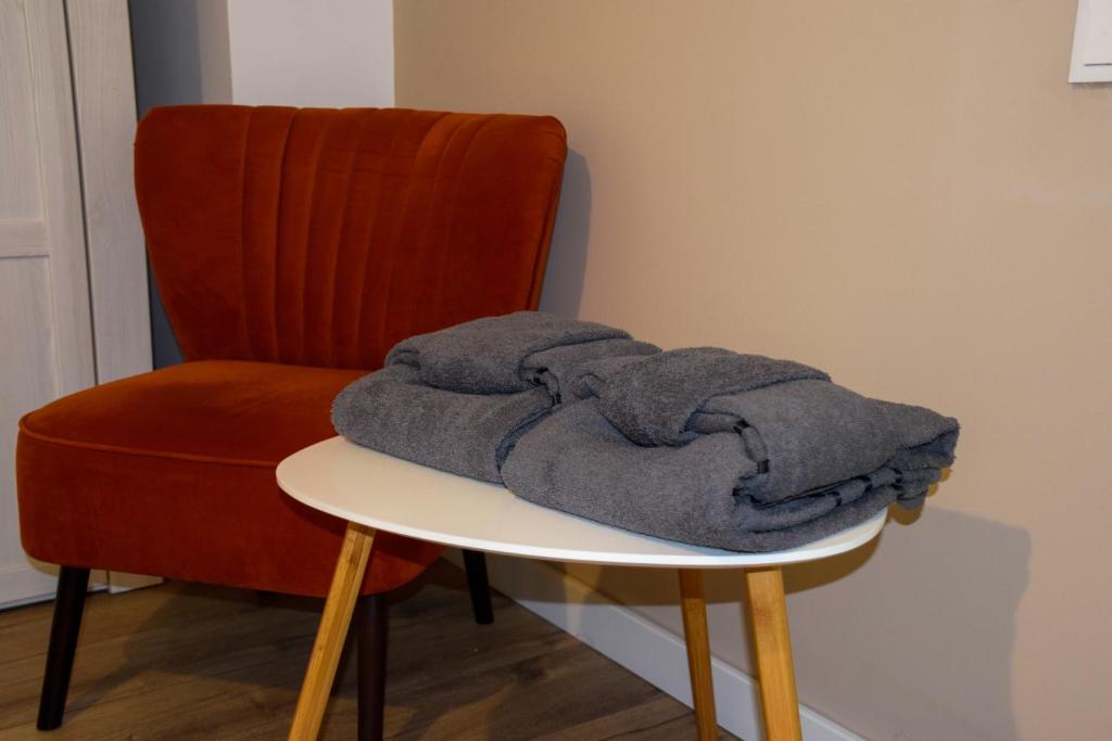 una pila di asciugamani appoggiata su un tavolo accanto a una sedia di Park home a Baia Mare