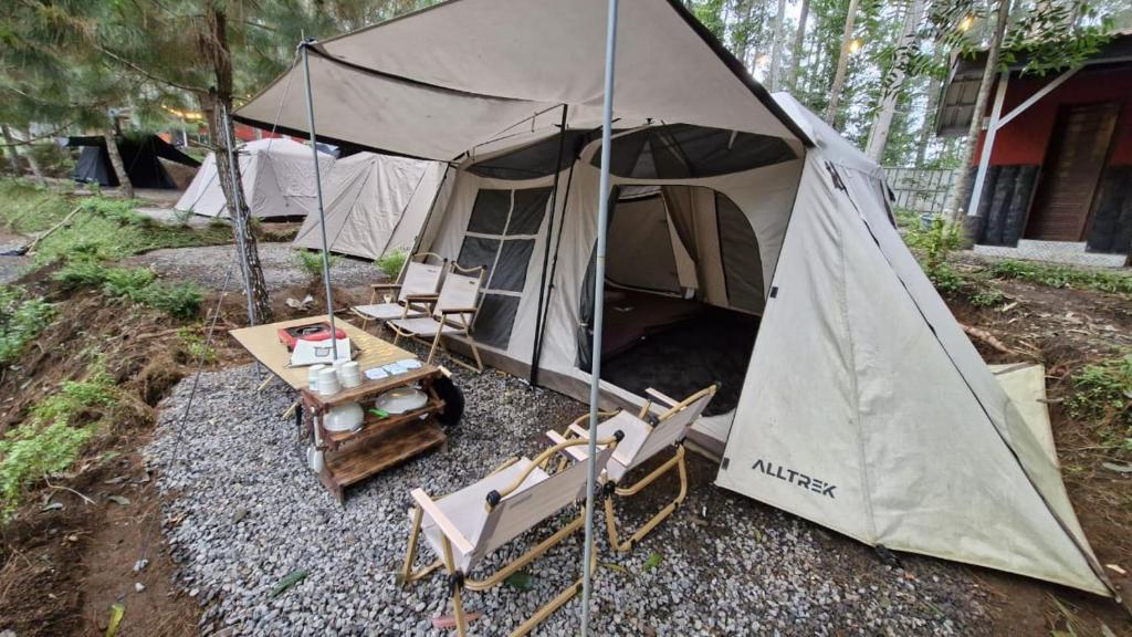 TangkubanperahuPakis Camping Cikole的庭院内带椅子和桌子的帐篷