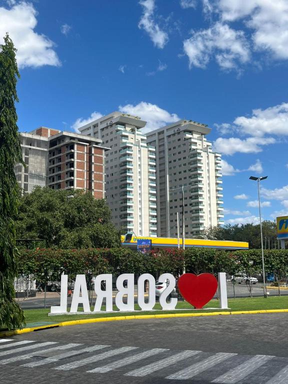 a sign with a heart on it in front of a city at Seller Residence Centro in Sobral