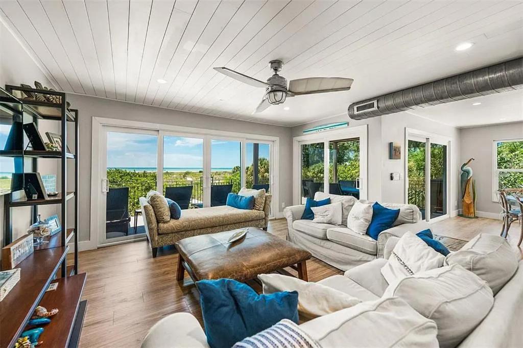 a living room with white furniture and a ceiling fan at A Tide that Binds Us By Beachside Management in Siesta Key