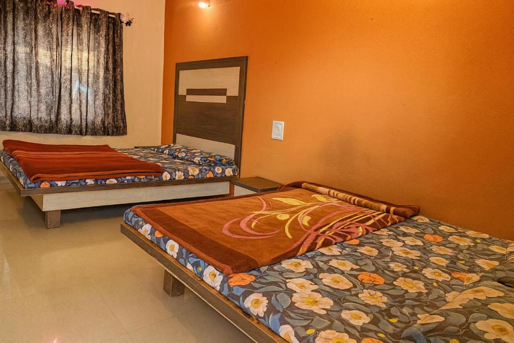 deux lits assis dans une pièce avec la hritisthritisthritisthritisthritisthritistite dans l'établissement Hotel Sudama Palace - Mahabaleshwar , Couple & Family Stay Rooms with Free Wi-Fi & Delicious Food, à Mahabaleshwar