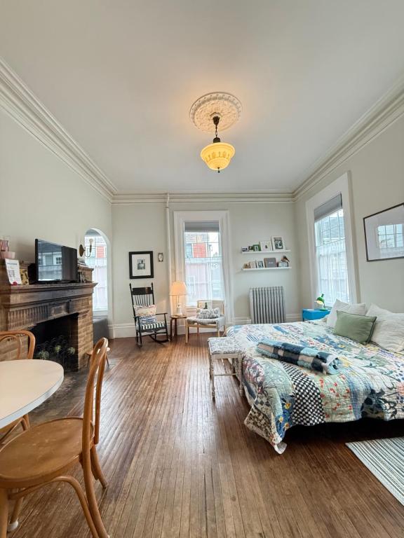 a bedroom with a bed and a table and a fireplace at Townhouse in Portsmouth Downtown Historic District in Portsmouth