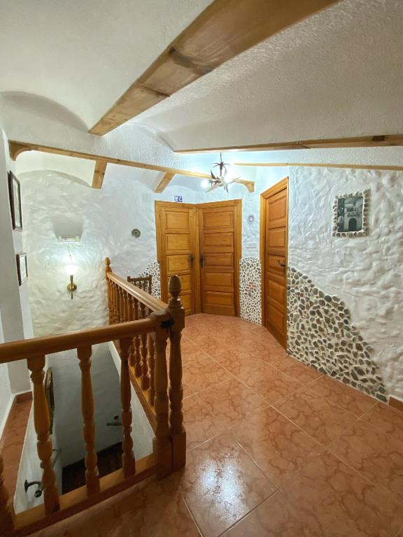 a hallway of a house with a staircase and a door at las 2 jotas in Guisando