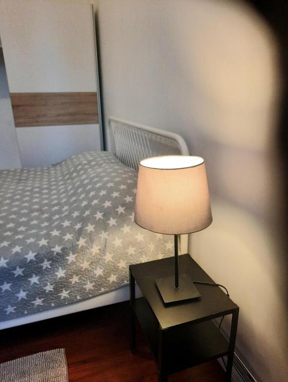 a bedroom with a bed with a lamp on a table at Stylish 2BR in Old Town Gem in Riga