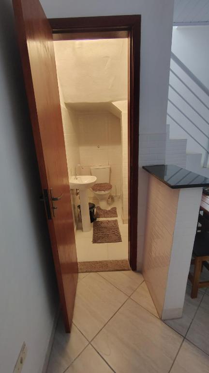 an open door to a bathroom with a sink at Casa na Guilhermina 500mt da praia in Praia Grande