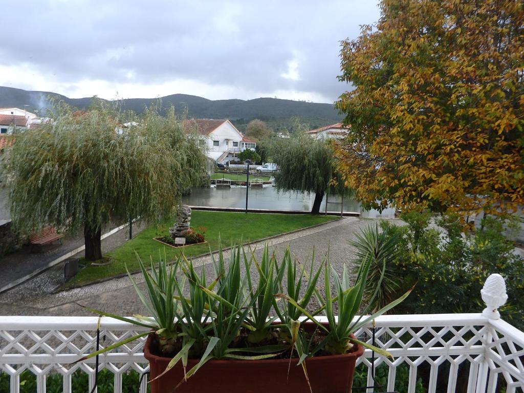 una vista de un río desde una cerca blanca con plantas en El Camino Lodge, en Redinha