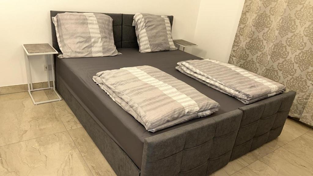 a bed with two pillows on it in a room at Schönes Apartment mit eigener Küche und eigenem Bad in Munich