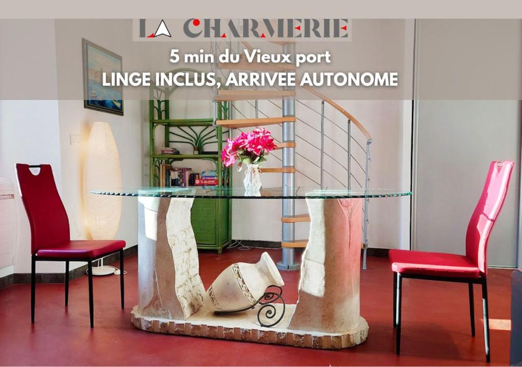 a glass table with two red chairs and a vase with flowers at ღ LA CHARMERIE Duplex climatisé à 5min du Vieux Port in Marseille