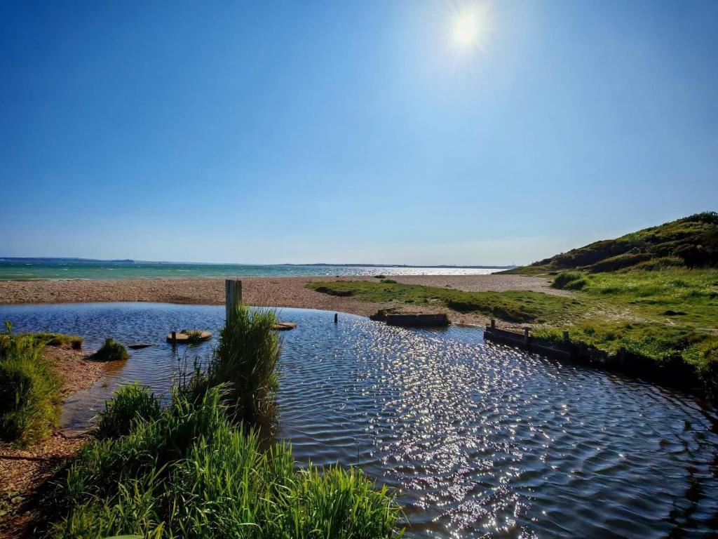 a body of water next to a sandy beach at Cabin 100 in Warsash