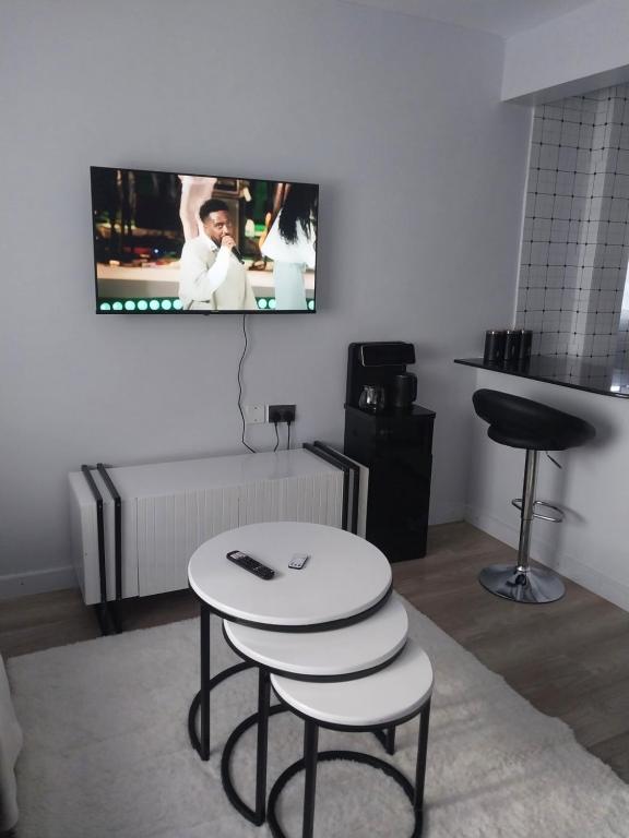 un soggiorno con tavolo e TV a parete di Empiris Luxe Homes a Narok