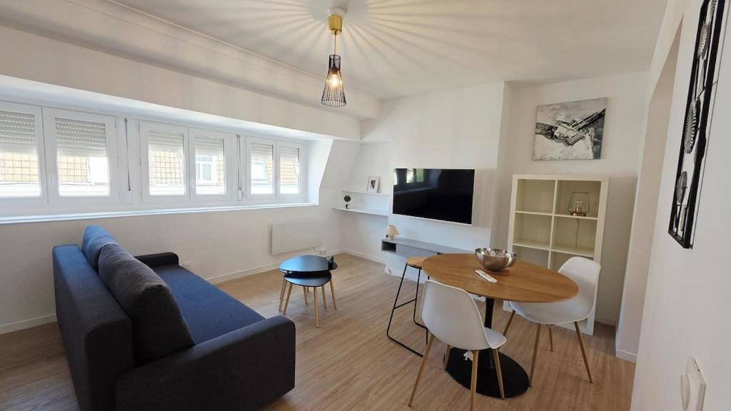 un salon avec un canapé bleu et une table dans l'établissement Le duplex de Belle Rade - proche centre et plage, à Dunkerque