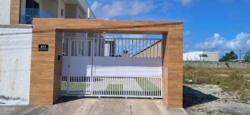 a white garage door with a white gate at Casa de Praia Nova, 3 quartos, 1 Suíte, com quintal privativo, em condomínio, muito bem Localizado in Porto Seguro