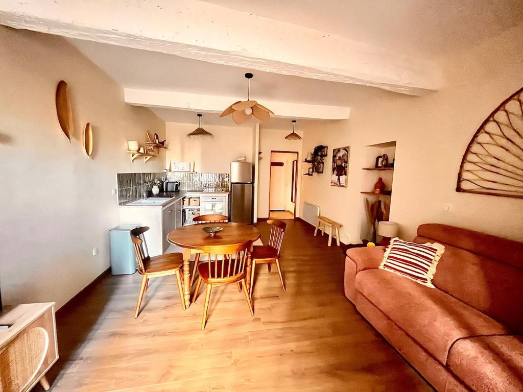 een woonkamer met een tafel en een bank bij Studio L'oasis Ensoleillé in Cuers