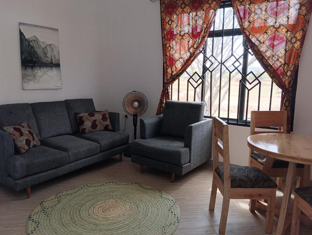 a living room with a couch and a chair and a table at Nyumbani House in Mto wa Mbu