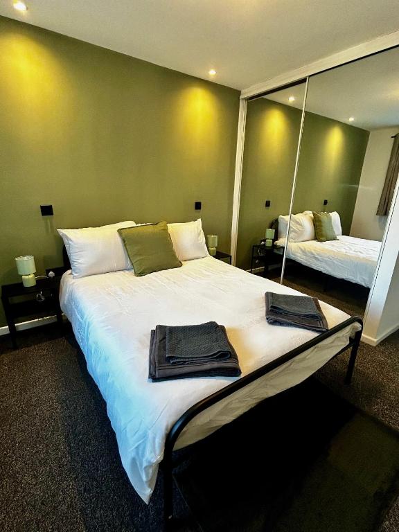 a bedroom with a large bed with two mirrors at Druridge Apartment in Blythe