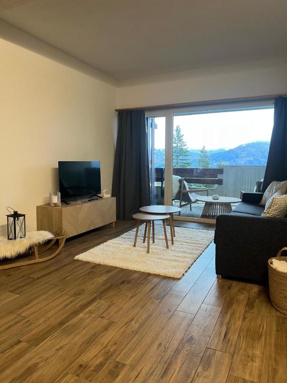 a living room with a couch and a table at Studio élégant rénové avec vue à Anzère in Anzère