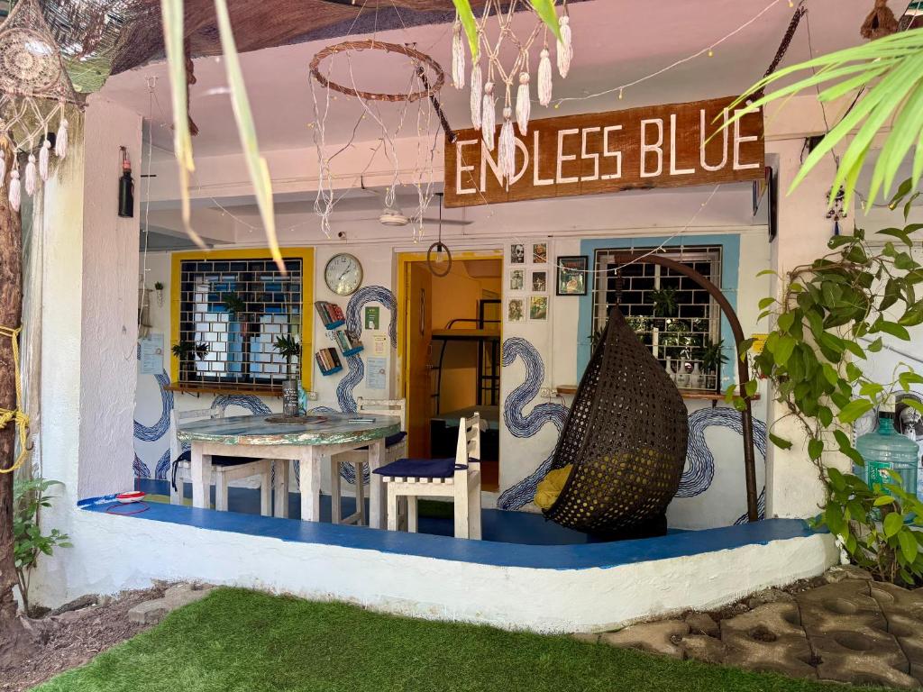 Ein Ladenlokal in einem Haus mit einem Tisch und Stühlen in der Unterkunft Endless Blue Hostel in North goa