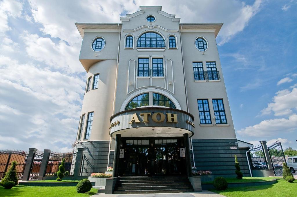 a white building with a entrance to a store at Aton Hotel in Krasnodar