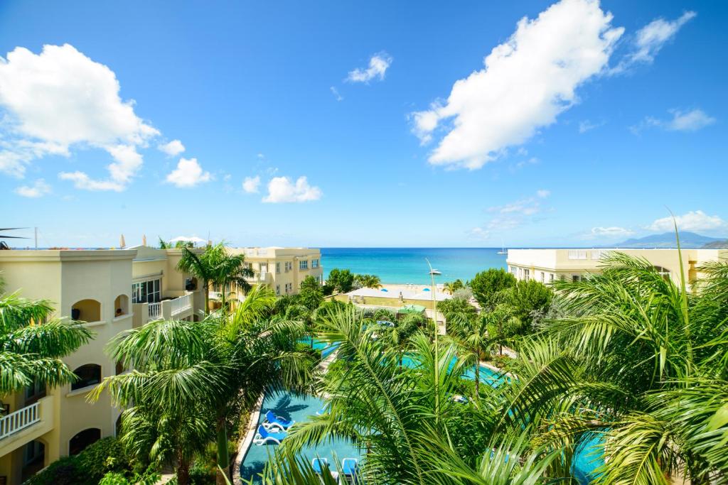vista su un resort con palme e sull'oceano di The Hamilton Beach Villas & Spa a Nevis