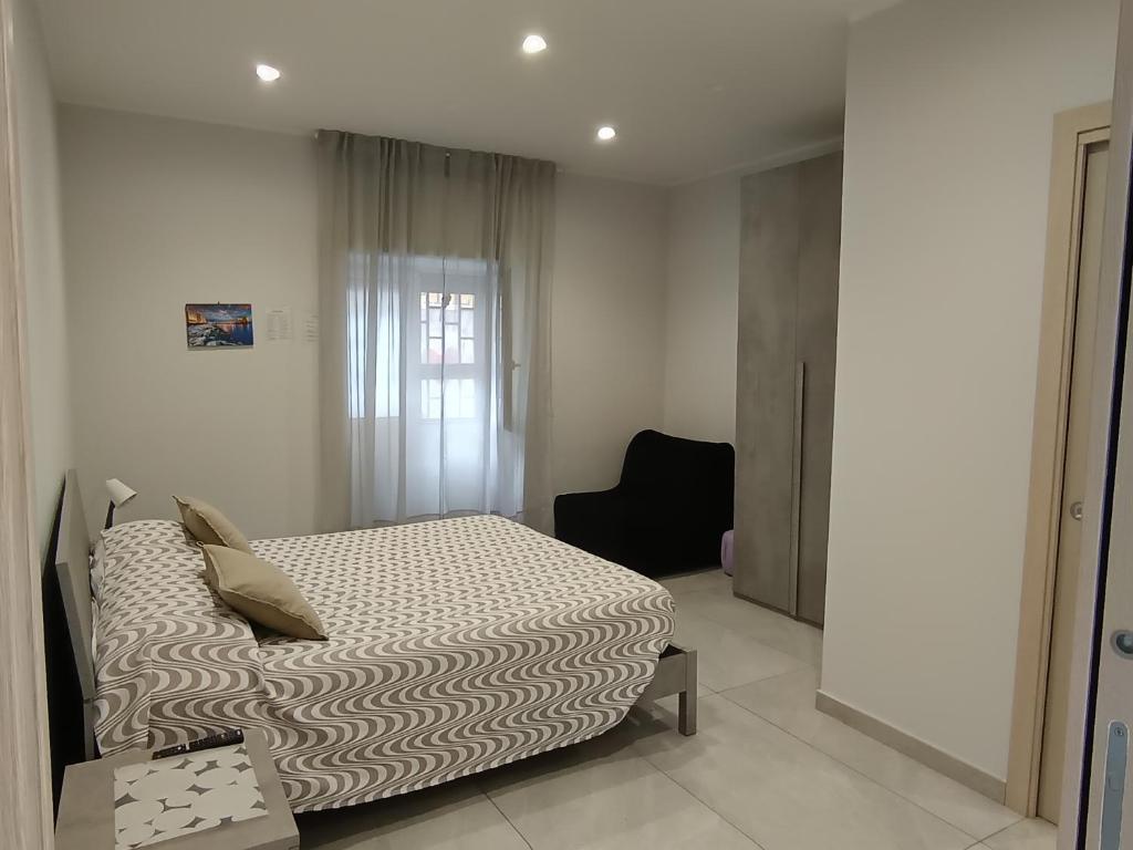 una camera da letto con un letto e una sedia di La casa di Flò a Ercolano