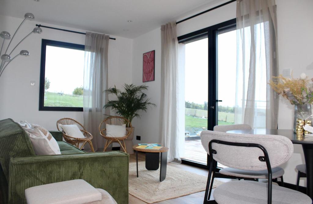 ein Wohnzimmer mit Sofa, Stühlen und einem Tisch in der Unterkunft Escale Doullennaise - Appartement neuf avec terrasse in Doullens