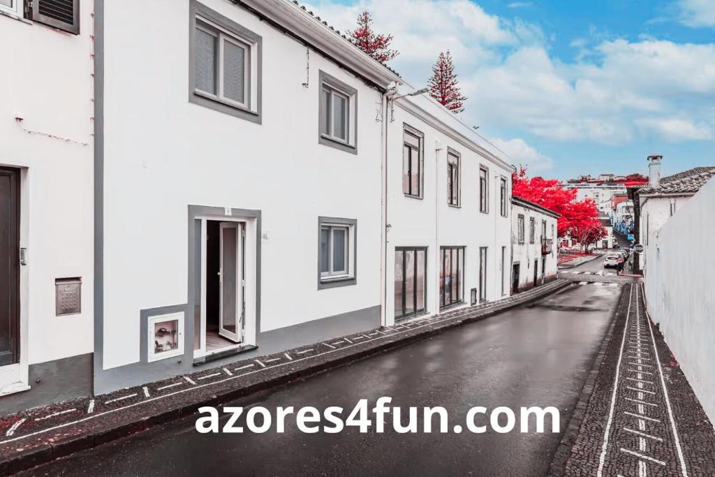 eine leere Straße mit weißen Gebäuden in einer Stadt in der Unterkunft Apartamentos Casas da Travessa T0 T2 T3 in Horta