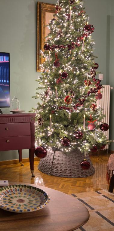 a christmas tree with lit candles in a living room at Timeless nest in Alexandroupoli