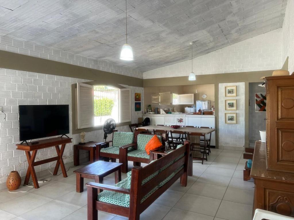 a living room with tables and chairs and a kitchen at Casa em Itamaracá - 70 metros da Praia in Itamaracá