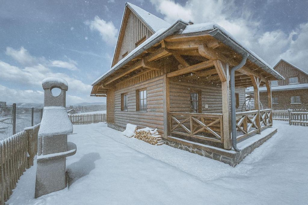 a log cabin in the snow with a roof at Drevenica pri Mare - Tatralake Log Cabin near Auqapark Tatralandia and lake Liptovska Mara in Liptovský Trnovec