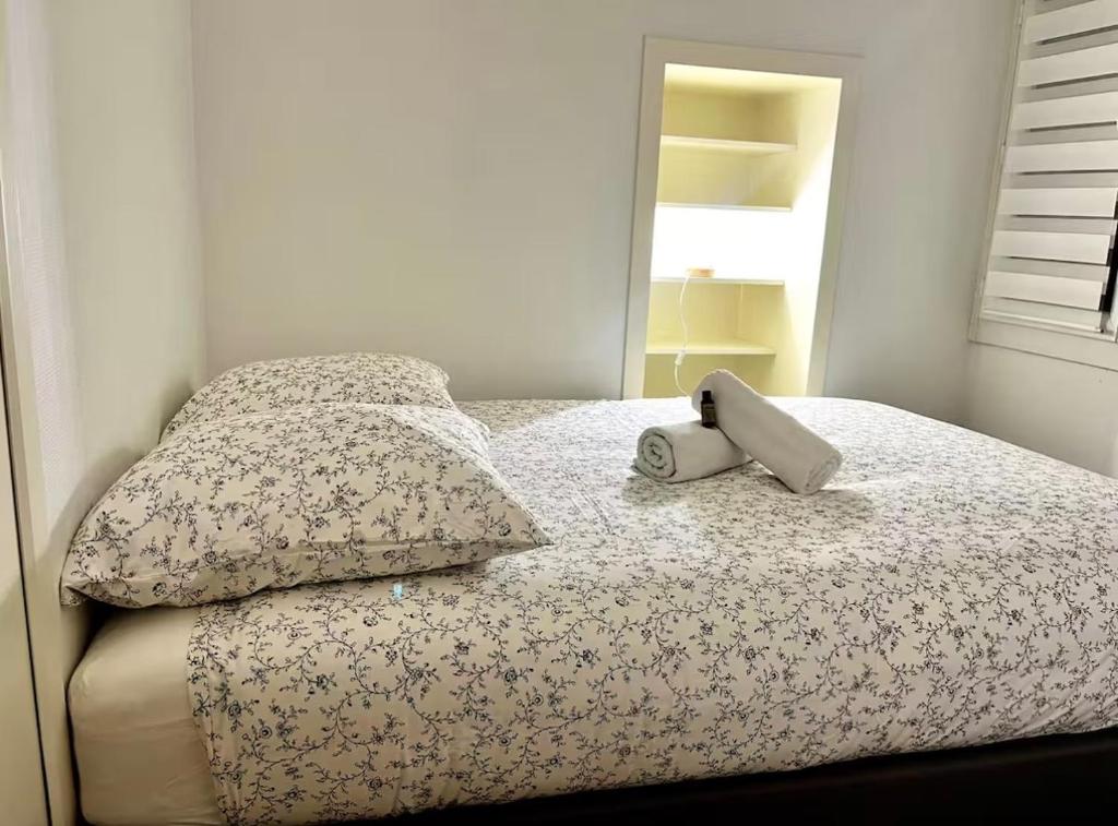 a bed with a pillow and a book on it at Pilori 2 pers, separate bedroom, Tv wifi in Nantes