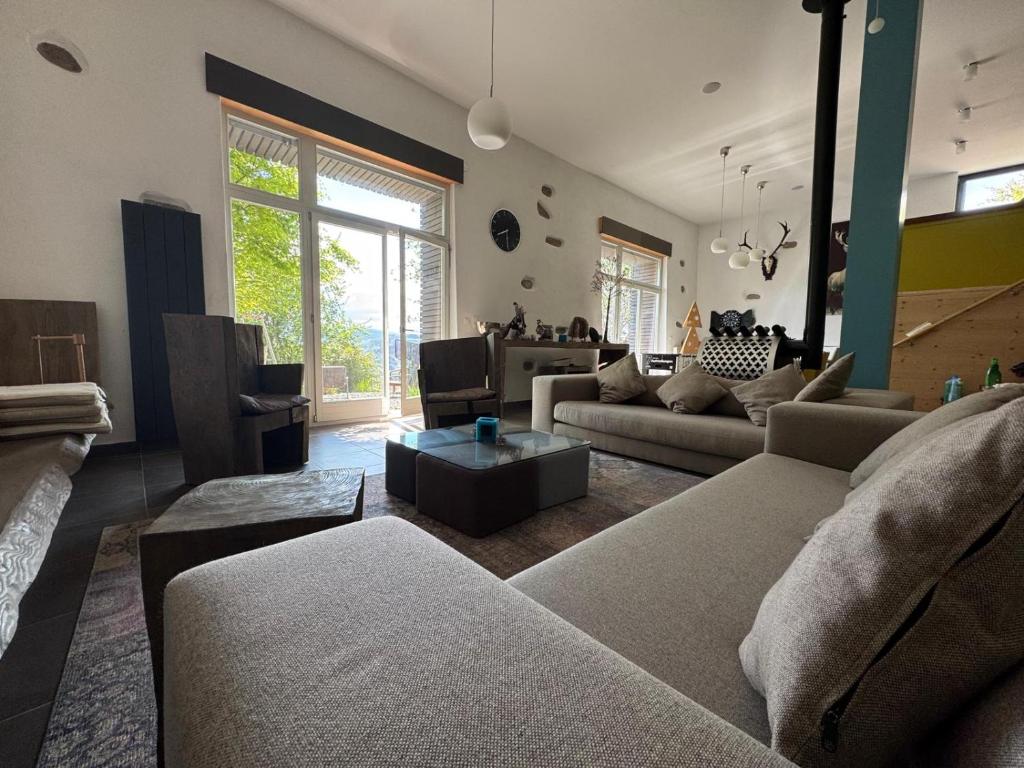 a living room with a couch and a table at A la folie des vosges in Fraize